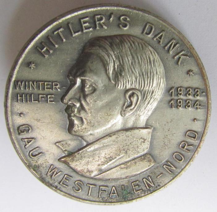 Commemorative - zinc-based- and/or silver-coloured - N.S.D.A.P.- (ie. WHW-) related 'tinnie', being a maker- (ie. 'Paulmann u. Crone'-) marked example depicting a portrait of Adolf Hitler surrounded by the text: 'Hitlers' Dank - Gau Westfalen Nord'