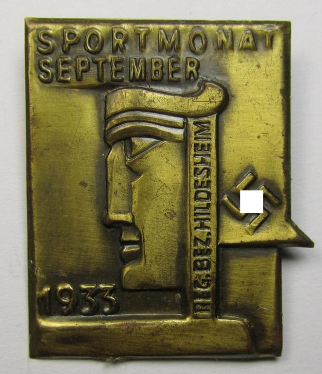 Bright-golden-toned, tin-based so-called: 'NS-sports'-related 'tinnie' being a non-maker-marked example depicting a stylised 'art-deco'-type figure and swastika coupled with the text: 'Sportmonat September 1935 - Reg. Bez. Hildesheim'