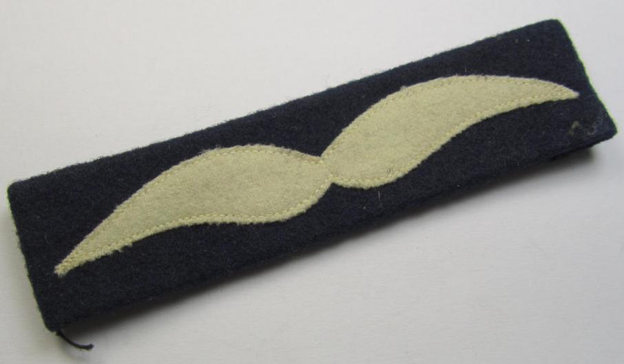 Single, WH (Luftwaffe) beige-coloured- and/or woolen-based, NCO-type rank-patch (aka 'moustache'), as was intended for usage by a non-commissioned officer with the rank of: 'Unteroffizier'