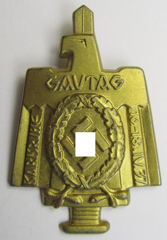 Commemorative, tin-based- and/or: bright golden-toned (I deem) N.S.D.A.P.-related 'tinnie' depicting an eagle-device resting on an upward-positioned sword and that is entitled: 'Gautag - Karlsruhe - 16.18. IV 1937'