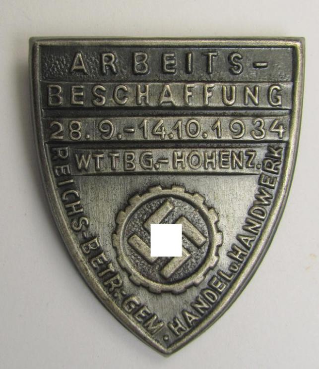 Silver-toned- (and/or tin-based) RAD- (ie. 'Reichsarbeitsdienst'-) related day-badge depicting a so-called: 'RAD-Zahnrad' and text: 'Arbeitsbeschaffung - 28.9.-14.10.1934 - Wttbg. Hohenz.' and sub-titled: 'Reichs-Betr. Gem. - Handel u. Handwerk'