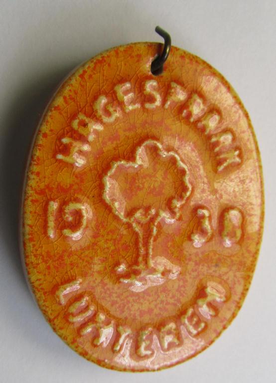 Dutch NSB-party-related, so-called: 'Hagespraak'-lapel-pin (ie. 'Veranstaltungsabzeichen' ie. tinnie) that is executed in orange-toned, ceramic-based material and that is depicting the text: 'Hagespraak - Lunteren 1938'