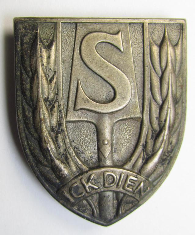 Attractive - and actually scarcely found! - Dutch WWII-period, labour service ie. 'Nederlandse Arbeidsdienst' (or: NAD) sports'-badge entitled: 'Ick Dien' being an example that is executed in silver-coloured metal