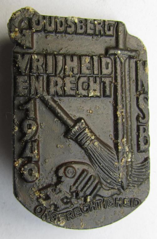 Dutch NSB-party-related, so-called: 'Hagespraak'-lapel-pin (ie. 'Veranstaltungsabzeichen' ie. tinnie) that is executed in golden-bronze-toned, aluminium-based metal and depicting the text: 'Goudsberg - Vrijheid en Recht - 1940'