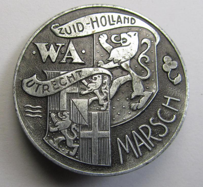 Attractive, Dutch NSB-party- (ie. WA)-related lapel-pin (ie. 'Veranstaltungsabzeichen' ie. tinnie) that is executed in zinc-based metal and that is depicting the text: 'WA-Marsch - Zuid-Holland - Utrecht' (1942)