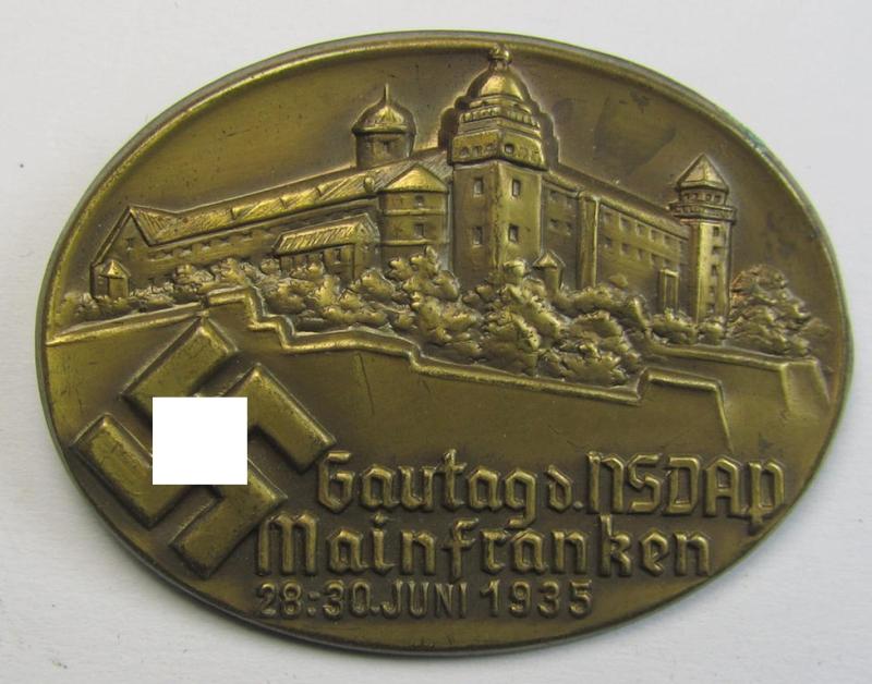 Commemorative, tin-based- and/or: golden-coloured, N.S.D.A.P.-related 'tinnie' being a non-maker marked example depicting a detailed illustration of a castle and bearing the text: 'Gautag d. NSDAP - Mainfranken - 28.30. Juni 1935'
