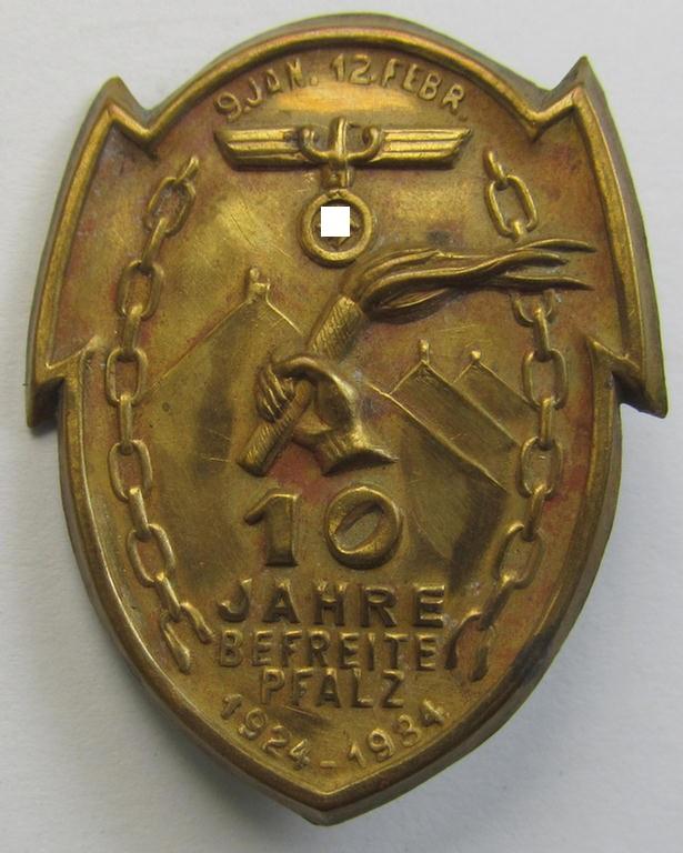 Commemorative - and truly unusally seen! - golden-coloured, N.S.D.A.P.-related 'tinnie' depicting a detailed illustration of a hand holding a torch and eagle-device coupled with the text: '9. Jan.-12. Febr. - 10 Jahre befreite Pfalz - 1924 - 1934'