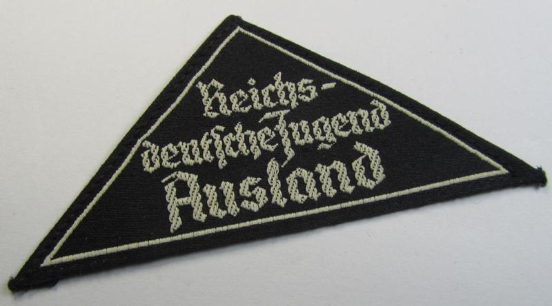 Superb - and rarely encountered! - HJ/BDM (ie. 'Hitlerjugend' or: 'Bund Deutsche Mädel') district-triangle (ie. 'Gebietsdreieck') entitled: 'Reichs-deutsche Jugend Ausland' being a virtually mint specimen that still retains its 'RzM'-etiket