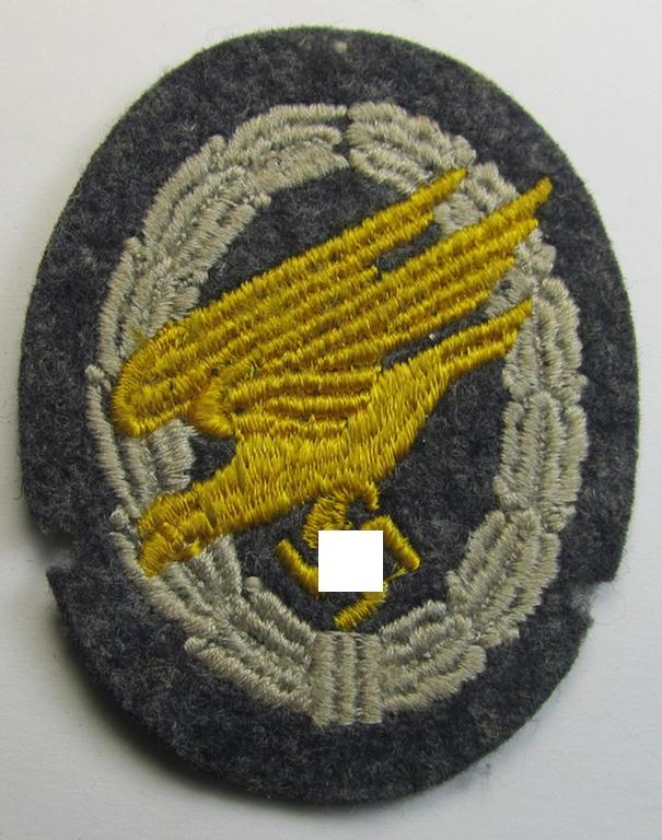Attractive, WH (Luftwaffe) 'Fallschirmschützen-Abzeichen in Stoff' (or: cloth-based paratroopers'-jump-badge) being a nicely machine-embroidered specimen that comes in a probably issued albeit (I deem) never used- ie. 'virtually mint', condition