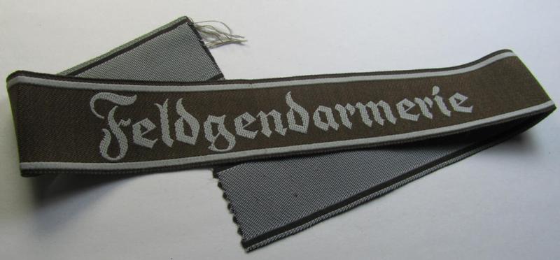 Superb - and scarcely encountered! - example of a WH (Heeres) cuff-title ie. armband (ie. 'Ärmelstreifen') entitled: 'Feldgendarmerie' (being a typical 'semi-BeVo'-woven!) example that comes in a minimally shortened, condition