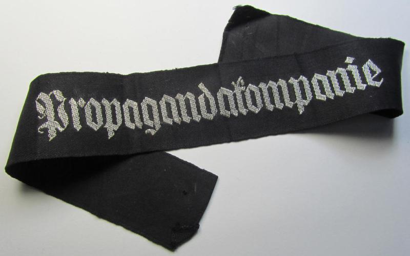 Superb - and most certainly rarely seen! - WH (Heeres) related cuff-title (ie. 'Ärmelstreifen') being a typical black-coloured- and linnen-based example showing the (neatly silver-toned- and 'flatwire'-woven!) text that reads: 'Propagandakompanie'