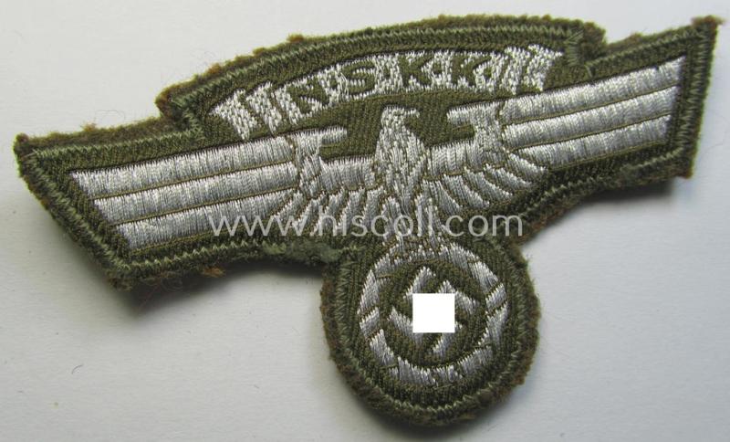 Attractive, greenish-tan-coloured, so-called: N.S.K.K. (ie. 'National Socialistisches Kraftfahr Korps') arm-eagle, still having its original-applied- and/or paper-based 'RzM'-etiket attached