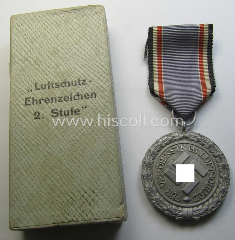 Attractive, light-weight (ie. typical aluminium-based) medal as was intended for air-raid wardens 2nd. class (or: 'Luftschutz-Ehrenzeichen 2. Stufe') that comes stored in its period, dove-grey-coloured etui
