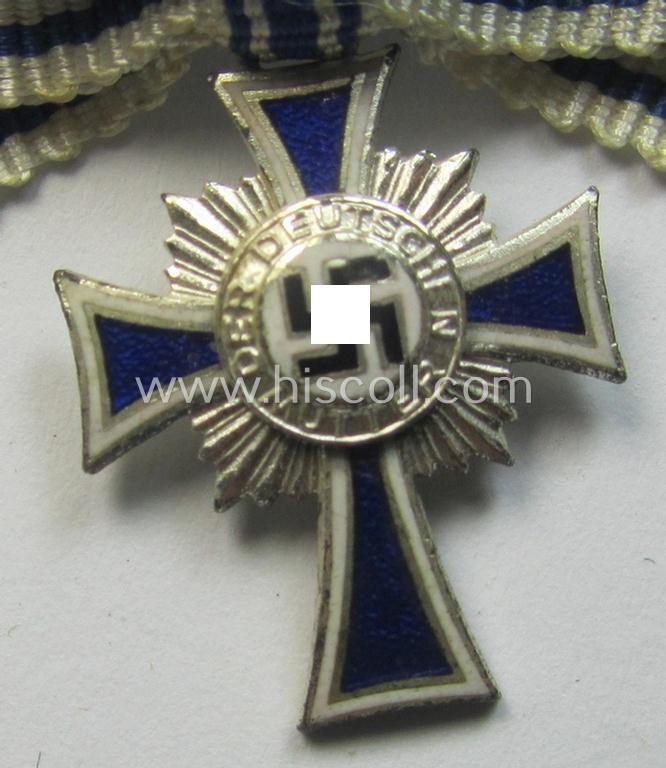 Miniature of an: 'Ehrenkreuz der deutschen Mutter - zweite Stufe' (or: silver-class mothers'-cross) being a neatly maker- (ie. 'L/60'-) marked example that comes in an overall nice- (albeit moderately worn- ie. used-), condition