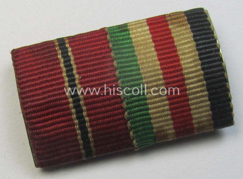 Two-pieced, WWII-period (ie. DAK-related!) medal-bar (ie. 'Band- o. Feldspange') showing resp. the ribbons for a: 'Medaille Winterschlacht im Osten 1941-42' (ie. 'Ost'- or Eastern-Front medal) and a: 'Deutsch-Italienische Feldzugsmedaille'