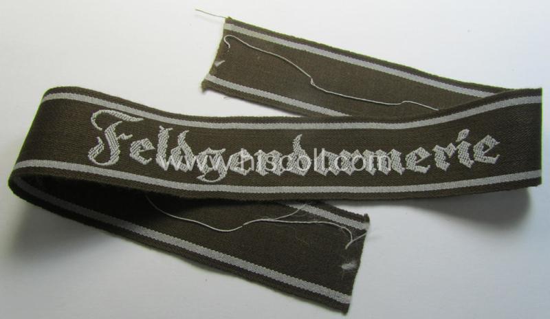 Superb - and scarcely encountered! - example of a WH (Heeres) cuff-title ie. armband (ie. 'Ärmelstreifen') entitled: 'Feldgendarmerie' (being a typical 'semi-BeVo'-woven!) example that comes in a full length- ie. non-shortened, condition