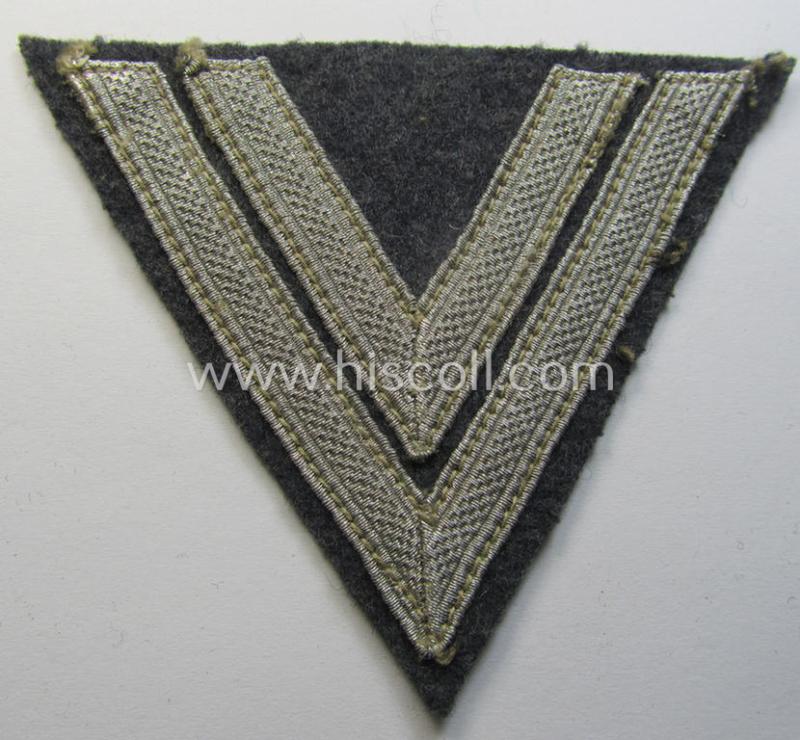 WH (Luftwaffe) 'Armwinkel' (or: arm-chevron) as executed on typical bluish-grey-coloured wool as was specifically intended for usage by a soldier with the rank of: 'Obergefreiter'