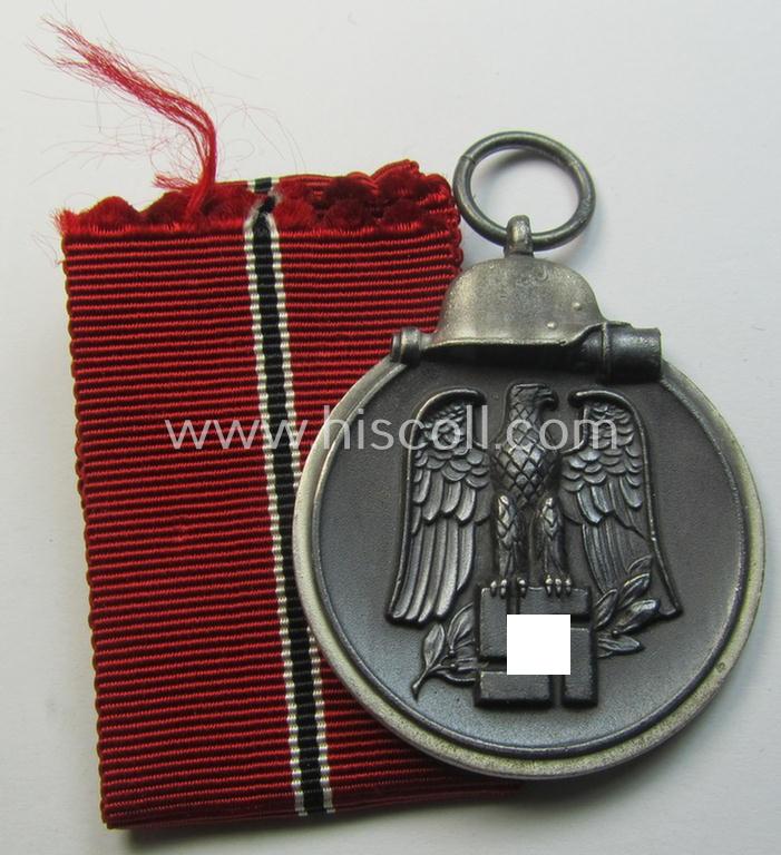 Attractive medal-set: 'Winterschlacht im Osten 1941-42' being a maker- (ie. '127'-) marked- (and/or 'Feinzink'-based) specimen by the maker: 'Moritz Hausch A.G.' and that comes together with its (non-confectioned) ribbon (ie. 'Bandabschnitt')