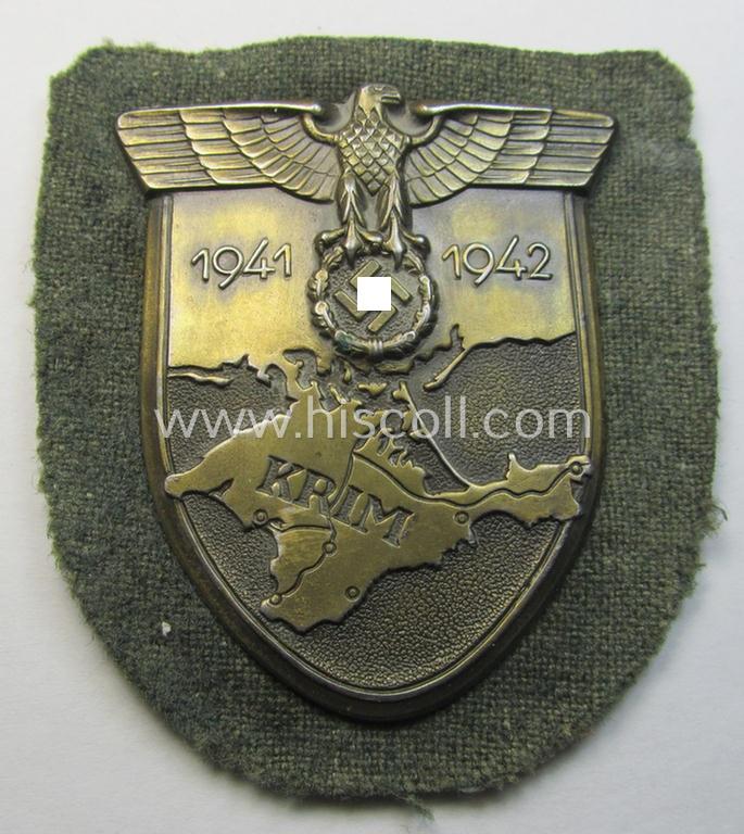 Superb, WH (Heeres o. Waffen-SS) 'Krim'-campaign-shield that comes mounted onto its original, field-grey-coloured 'backing' and that comes in a surely issued-, minimally worn and/or (I deem) carefully tunic-removed-, condition