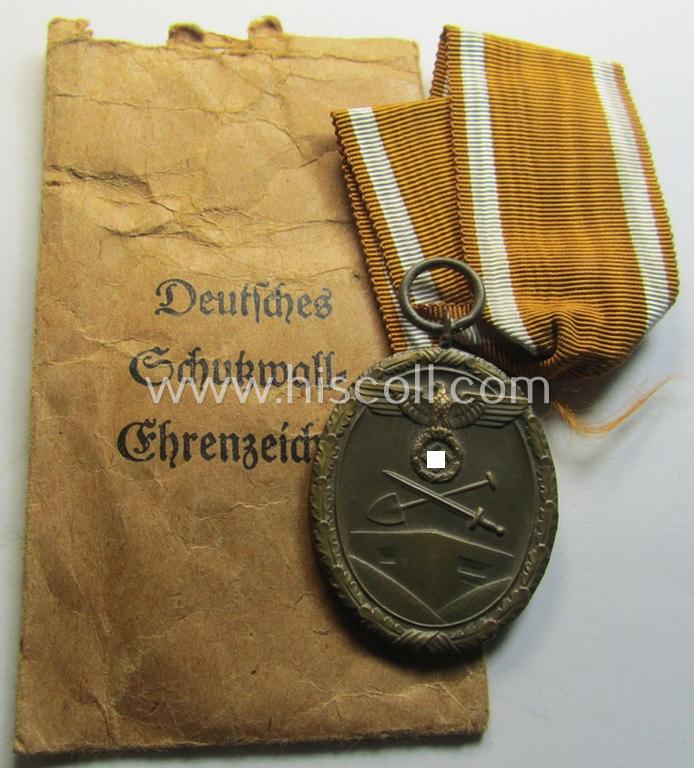 Attractive medal-set: 'Deutsches Schutzwall Ehrenzeichen' (aka: 'Westwall'-medal) being a typical non-maker-marked- and/or 'Buntmetall'-based specimen that comes packed in its original pouch of issue by the: 'Moritz Hausch A.G.'-company