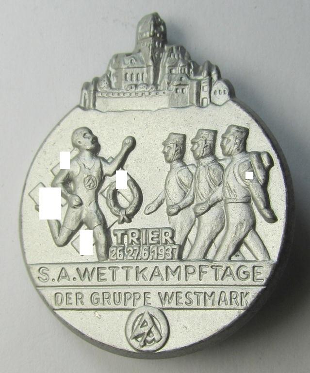 Commemorative, silvered tin-based so-called: SA- (ie. 'Sturmabteilungen'-) related 'tinnie' being a non-maker-marked example showing some marching storm-troopers and text: 'S.A. Wettkampftage der Gruppe Westmark - Trier - 26.27.6.1937'