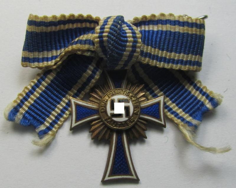 Miniature of an: 'Ehrenkreuz der deutschen Mutter - dritte Stufe' (or: bronze-class mothers'-cross) being a maker- (ie. 'L/14'-) marked example that comes in an overall nice- (albeit moderately worn- ie. used-), condition