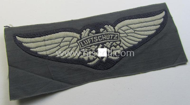 Attractive - and scarcely encountered! - EM- (ie. NCO-) pattern, so-called: 'Luftschutz' (ie. RLB-) cap-badge (ie. 'Mützenabzeichen') as executed in so-called: 'BeVo'-weave-pattern and that comes in a 'virtually mint- ie. unissued' condition