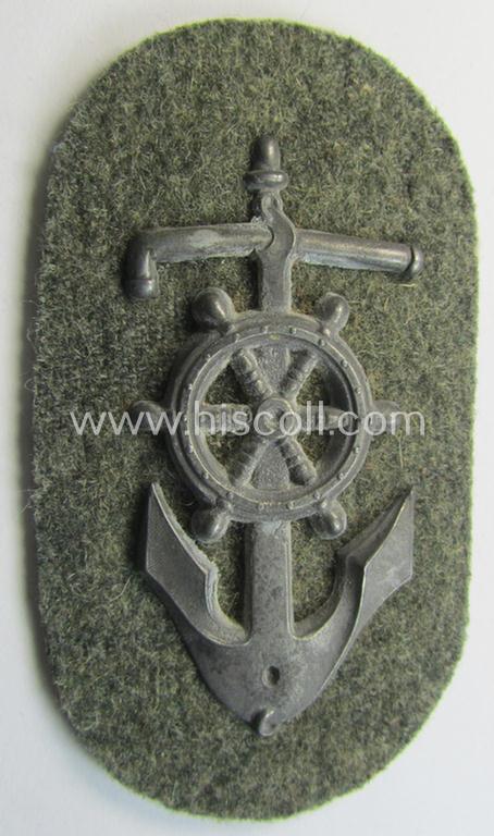 Superb - and rarely seen! - WH (Heeres) trade- and/or special-career insignia being a detailed- and/or silver-toned, 'Feinzink'-based example as executed on field-grey-coloured wool as was intended for a: 'Steuermann' (ie. enigineer-boat-pilot)