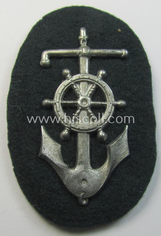 Superb - and rarely seen! - WH (Heeres) trade- and/or special-career insignia being a detailed- and/or silver-toned, 'Feinzink'-based example as executed on darker-green-coloured wool as was intended for a: 'Steuermann' (ie. enigineer-boat-pilot)