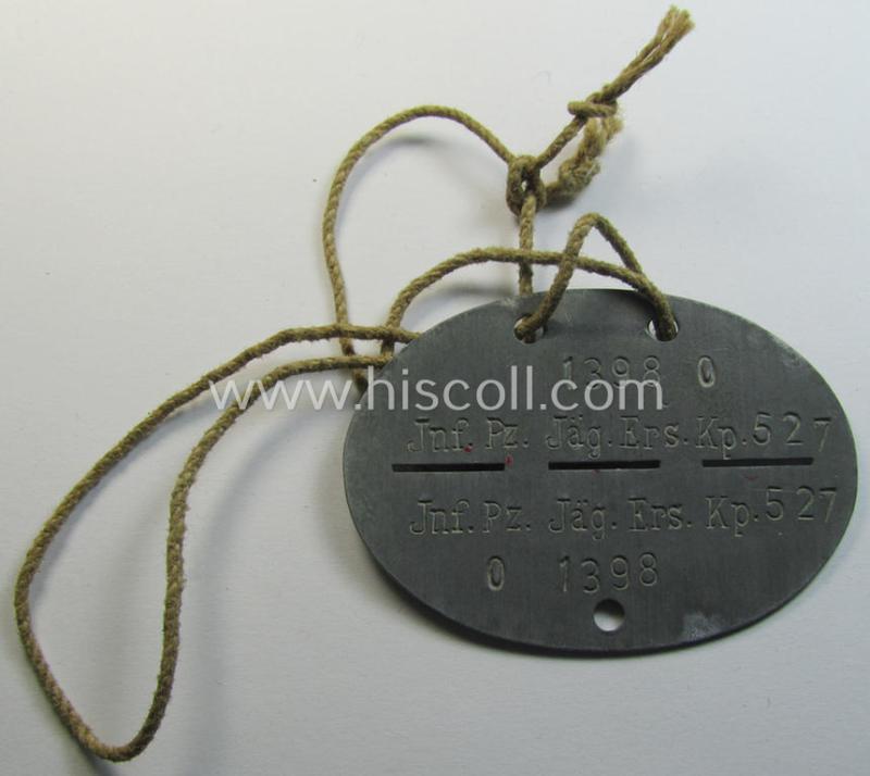 Attractive, zinc-based WH (Heeres) (ie. 'Pz-Jäger'-related) ID-disc bearing the clearly stamped unit-designation that reads: 'Inf.Pz.Jäg.Ers.Kp. 527' and that comes still mounted onto its (period-attached) cord as issued- and/or worn