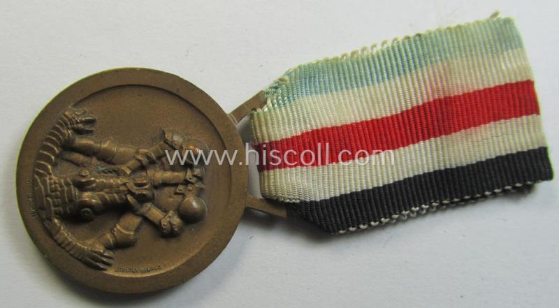 Attractive, golden-bronze-coloured- (and I deem 'Buntmetall'-based-) example of a: 'Deutsch-Italienische Feldzugsmedaille' (or: German-Italian campaign-medal) that comes mounted onto its (regular-sized) piece of original ribbon