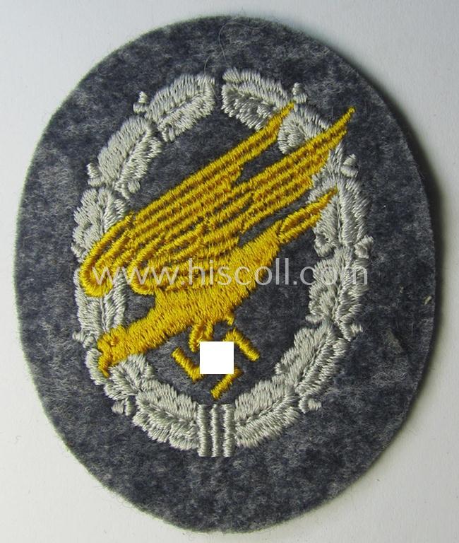 WH (Luftwaffe) 'Fallschirmschützen-Abzeichen in Stoff' (or: cloth-based paratroopers'-jump-badge) being a nicely machine-embroidered specimen that comes in a probably issued albeit (I deem) never used- ie. 'virtually mint', condition