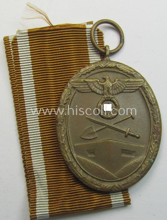 Medal-set: 'Deutsches Schutzwall Ehrenzeichen' (aka: 'Westwall'-medal) being a non-maker-marked- and/or: 'Buntmetall'-based specimen that comes together with its period- (and neatly folded ie. pre-confectioned) ribbon (ie. 'Bandabschnitt')