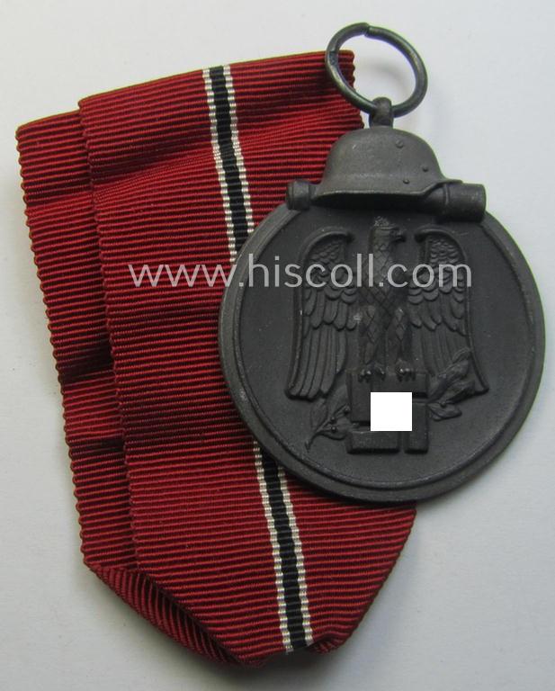 Neat medal-set: 'Winterschlacht im Osten 1941-42' being a maker- (ie. '93'-) marked- (and/or 'Feinzink'-based) specimen by the maker: 'Richard Simm & Söhne' and that comes together with its (minimally confectioned) ribbon (ie. 'Bandabschnitt')