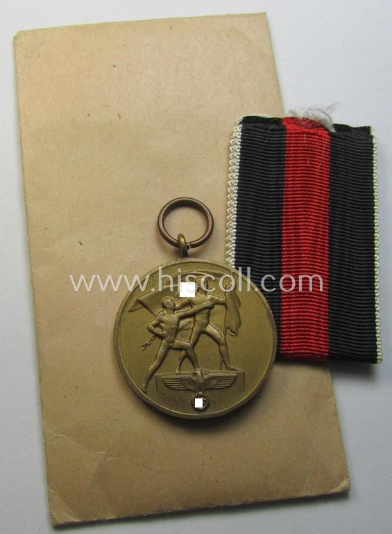 Superb, WH Czech occupation-medal '1 October 1938' and accompanying (mint- & non-confectioned) ribbon (ie. 'Bandabschnitt') that comes stored in its original, carton-based pouch as was produced by the maker: 'Eugen Schmidhäussler'