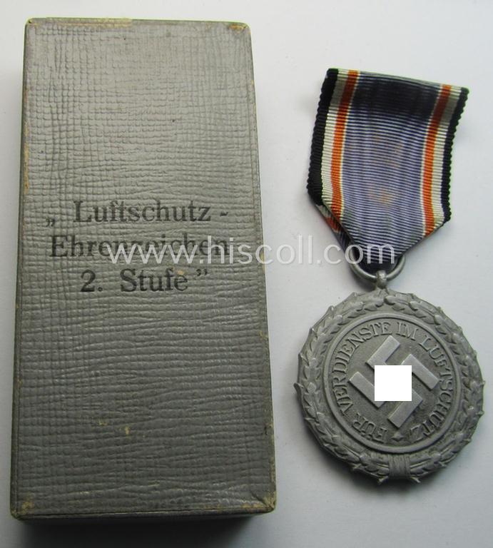 Attractive, light-weight (ie. typical aluminium-based) medal as was intended for air-raid wardens 2nd. class (or: 'Luftschutz-Ehrenzeichen 2. Stufe') that comes stored in its period, dove-grey-coloured etui