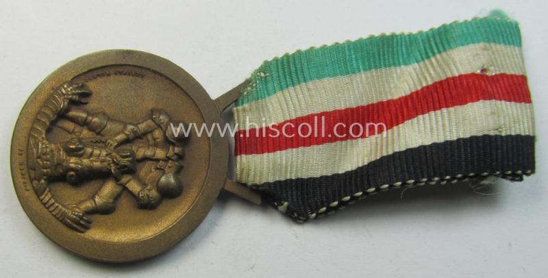 Attractive, golden-bronze-coloured- (and I deem 'Buntmetall'-based-) example of a: 'Deutsch-Italienische Feldzugsmedaille' (or: German-Italian campaign-medal) that comes mounted onto its (regular-sized) piece of original (and hardly faded!) ribbon