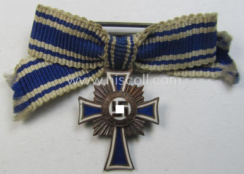 Miniature of an: 'Ehrenkreuz der deutschen Mutter - dritte Stufe' (or: bronze-class mothers'-cross) being a non-maker-marked example that comes in an overall nice- (albeit moderately worn- ie. used-), condition