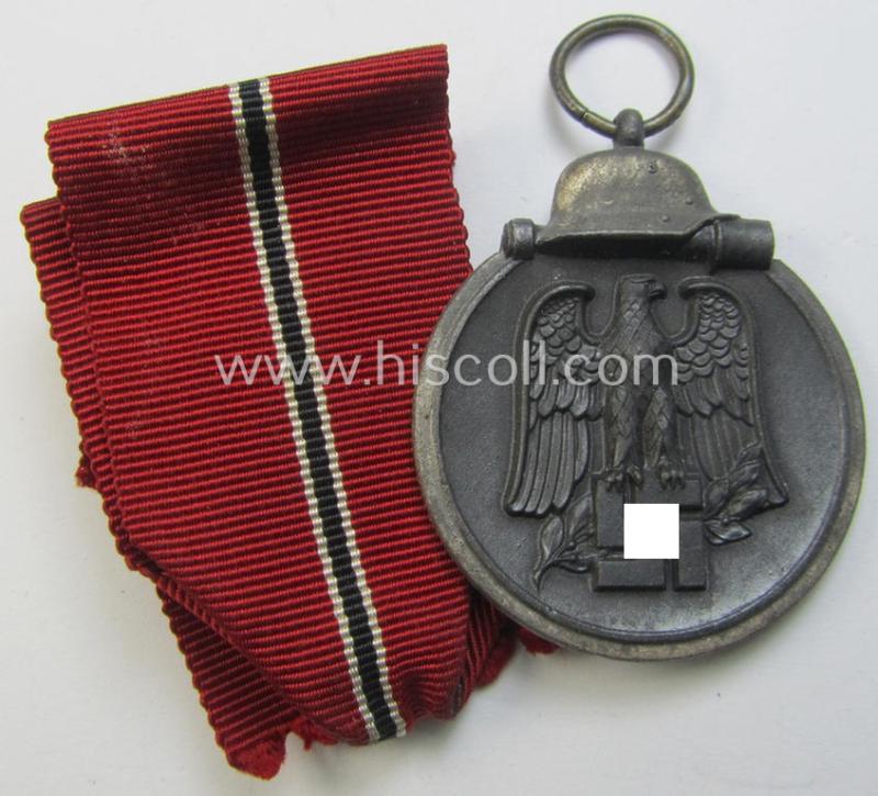 Neat medal-set: 'Winterschlacht im Osten 1941-42' being a maker- (ie. '93'-) marked- (and/or 'Feinzink'-based) specimen by the maker: 'Richard Simm & Söhne' and that comes together with its (minimally confectioned) ribbon (ie. 'Bandabschnitt')