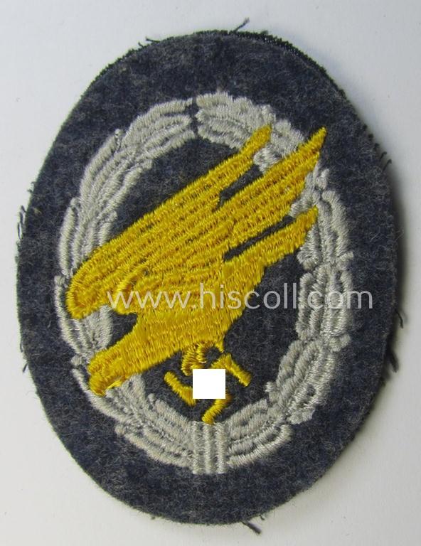 Attractive, WH (Luftwaffe) 'Fallschirmschützen-Abzeichen in Stoff' (or: cloth-based paratroopers'-jump-badge) being a nicely machine-embroidered specimen that comes in a probably issued albeit (I deem) never used- ie. 'virtually mint', condition