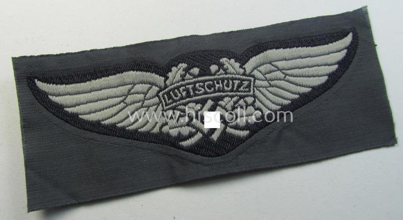 Attractive - and scarcely encountered! - EM- (ie. NCO-) pattern, so-called: 'Luftschutz' (ie. RLB-) cap-badge (ie. 'Mützenabzeichen') as executed in so-called: 'BeVo'-weave-pattern and that comes in a 'virtually mint- ie. unissued' condition