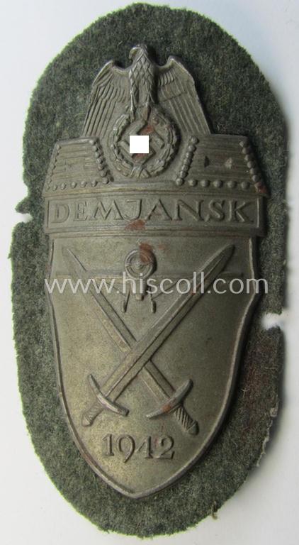 Attractive example of a - fairly scarcely encountered! - WH (Heeres ie. Waffen-SS) 'Demjansk'-campaign-shield as executed in typical magnetic metal (ie. so-called: 'Eisenblech') and that comes in an overall very nice- ie. fully untouched, condition