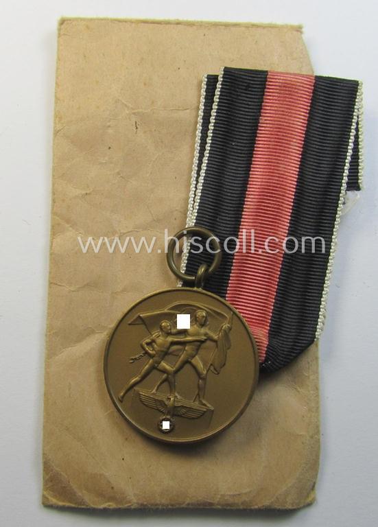 Superb, WH Czech occupation-medal '1 October 1938' and accompanying (mint- & non-confectioned) ribbon (ie. 'Bandabschnitt') that comes stored in its original, carton-based pouch as was produced by the (unusual!) maker: 'Otto Fechler'