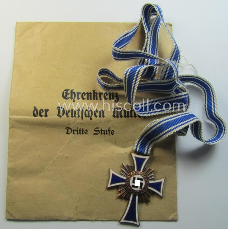 Attractive, 'Ehrenkreuz der deutschen Mutter - dritte Stufe' (or: bronze-class mothers'-cross) that came mounted onto its long-sized ribbon and that came stored in its period pouch (by the maker: 'C.Th. Dicke - Lüdenscheid')