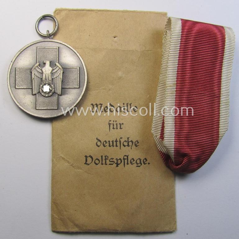 Attractive medal-set: 'Medaille für Deutsche Volkspflege' being a typical non-maker-maker-marked specimen that comes packed in its original pouch of issue by the: 'Hauptmünzamt Wien'-company as issued and/or recently found