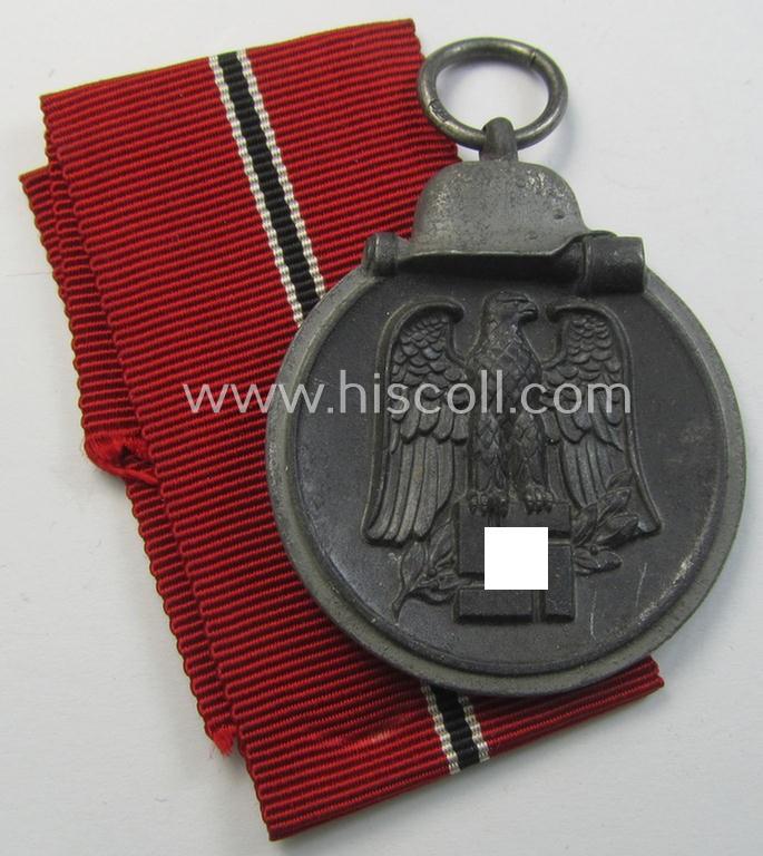 Neat medal-set: 'Winterschlacht im Osten 1941-42' being a maker- (ie. '76'-) marked- (and/or 'Feinzink'-based) specimen by the maker: 'Ernst L. Müller' and that comes together with its (non-confectioned) ribbon (ie. 'Bandabschnitt')