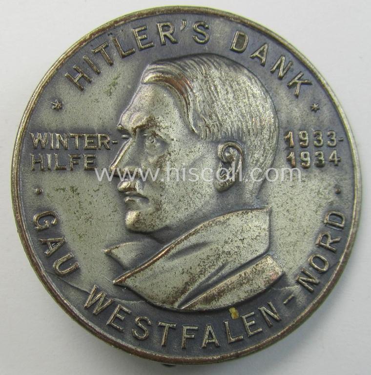 Commemorative, silvered 'Buntmetall'-based N.S.D.A.P.- (ie. WHW-) related 'tinnie' being a maker- (ie. 'Paulmann u. Crone'-) marked example depicting Adolf Hitler and showing the text: 'Hitler's Dank - Winterhilfe 1933-1934 - Gau Westfalen-Nord'