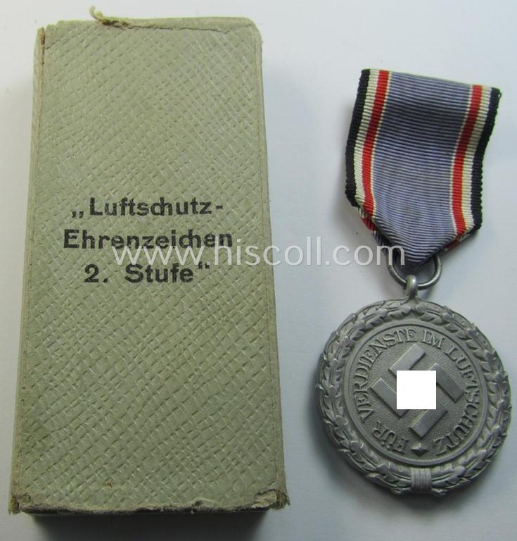Attractive, regular-weight (ie. typical zinc-based) medal as was intended for air-raid wardens 2nd. class (or: 'Luftschutz-Ehrenzeichen 2. Stufe') that comes stored in its period (albeit damaged), dove-grey-coloured etui