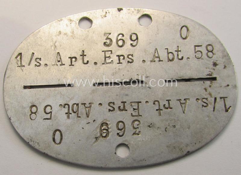 Aluminium-based, WH (Heeres) ie. 'schwere Artillerie'-related ID-disc (ie. 'Erkennungsmarke') bearing the stamped unit-designation that reads: '1./Art.Ers.Abt. 58'