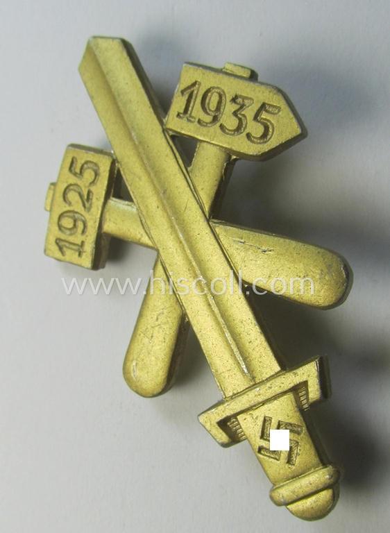 Commemorative, golden-coloured, N.S.D.A.P.-related 'tinnie' being a maker- (ie. 'Hofstätter - Bonn'-) marked example depicting a detailed, upright-positioned sword and two 'hammers' and swastika and bearing the dates: '1925 - 1935'